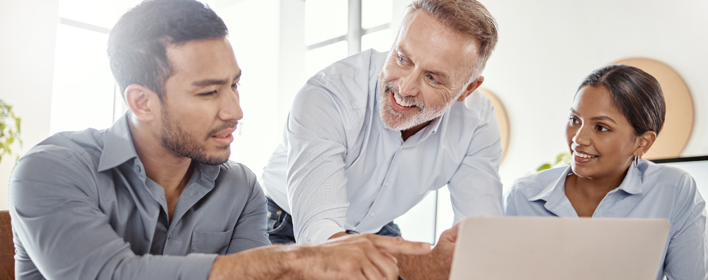 Three people smiling looking at computer screen