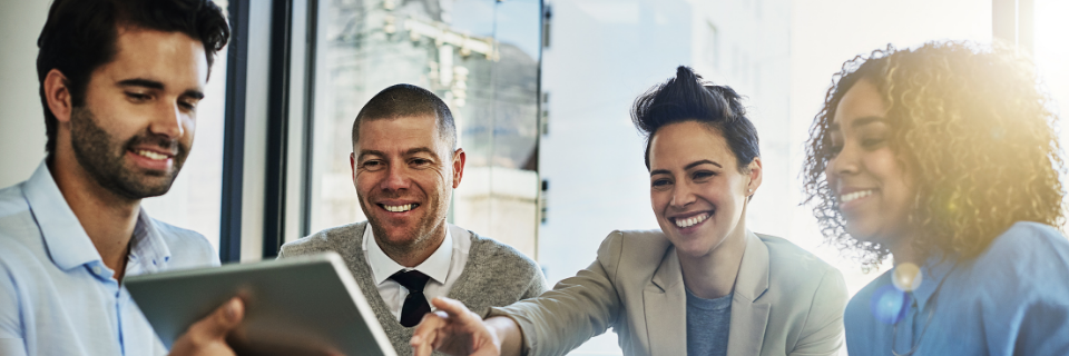 Group of people smile and point at screen