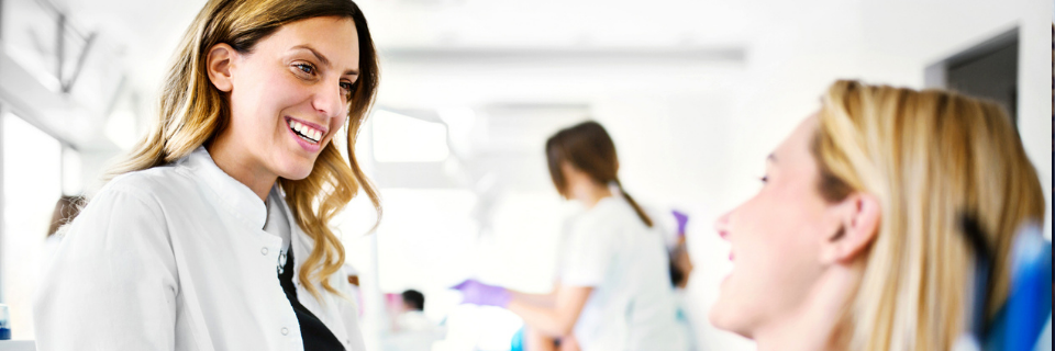 Provider smiles at patient in dentist chair