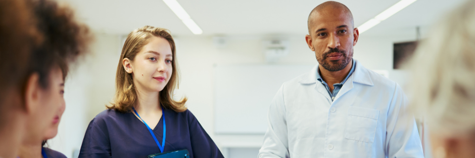 Two providers stand in front of a group of people