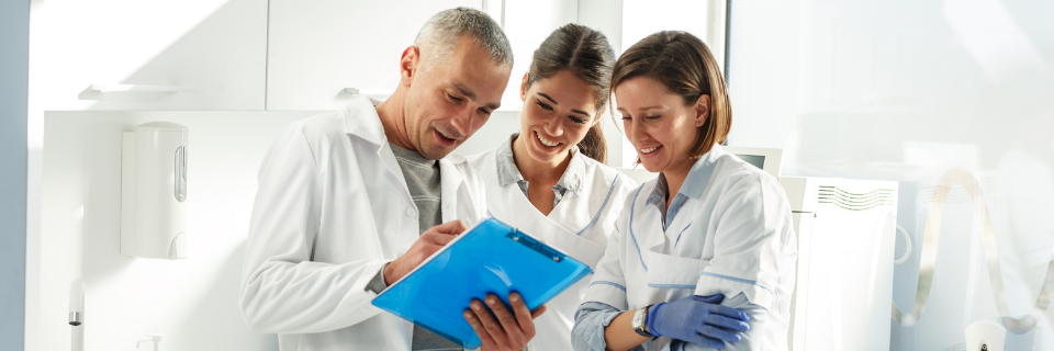 Group of dental providers standing together, looking at info